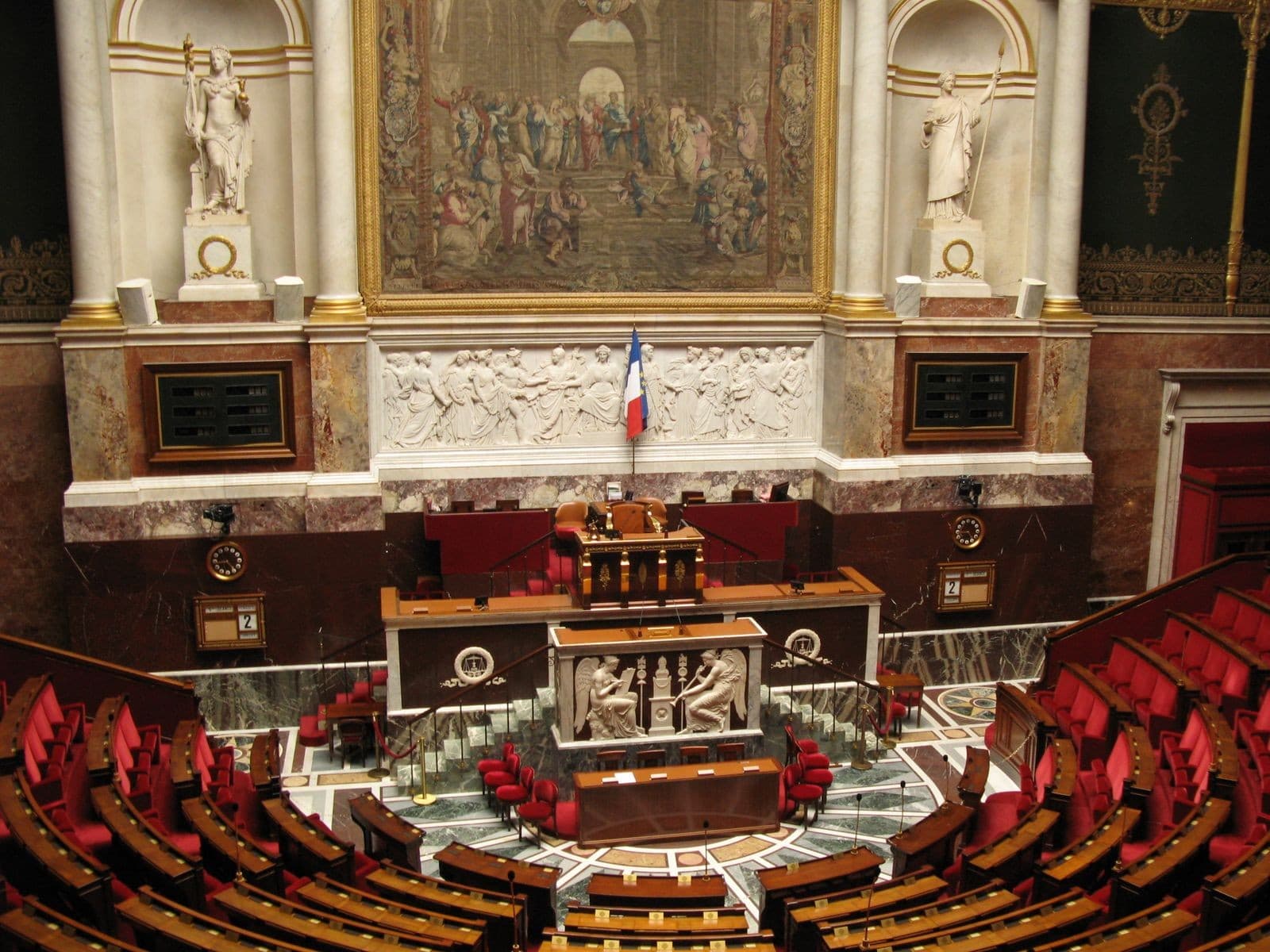 Hémicycle vide de l'Assemblée nationale, sièges rouges, drapeau tricolore, fresque au plafond